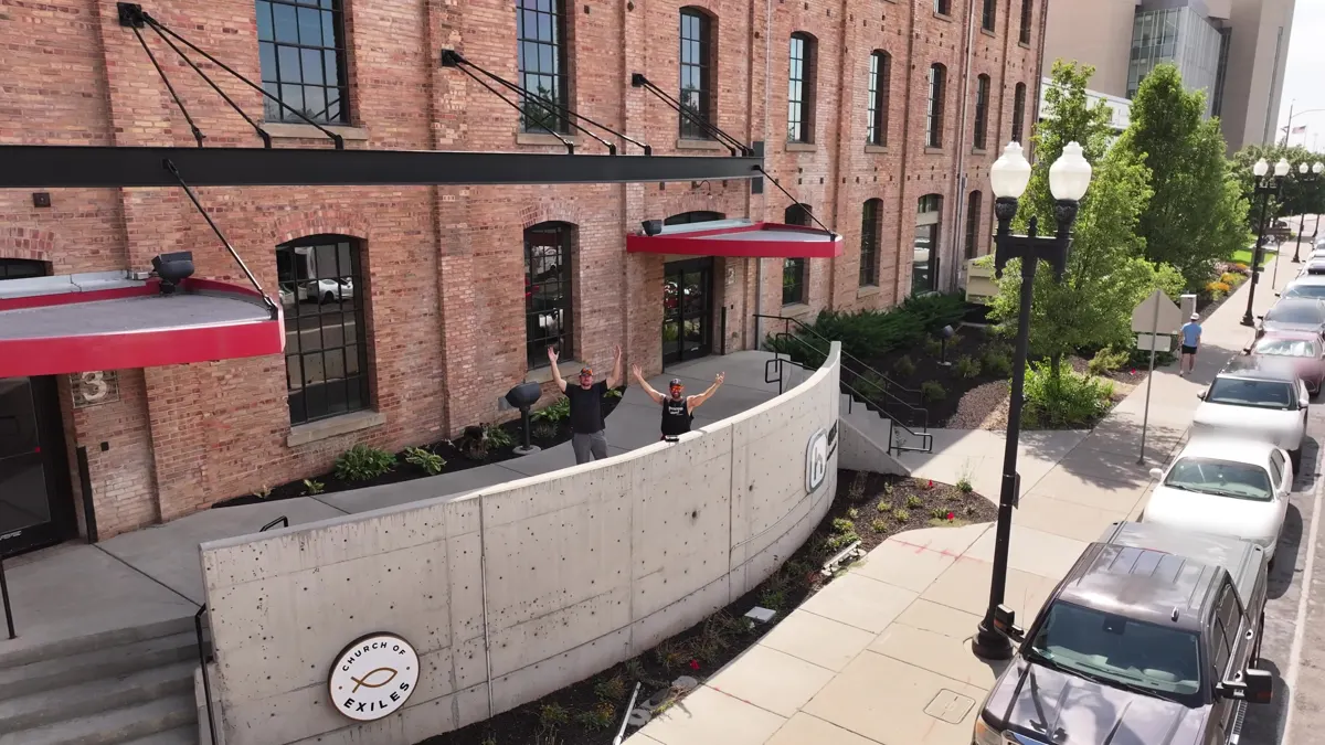Our brick building at 251 20th St. with red awnings and the Church of Exiles sign by the front steps