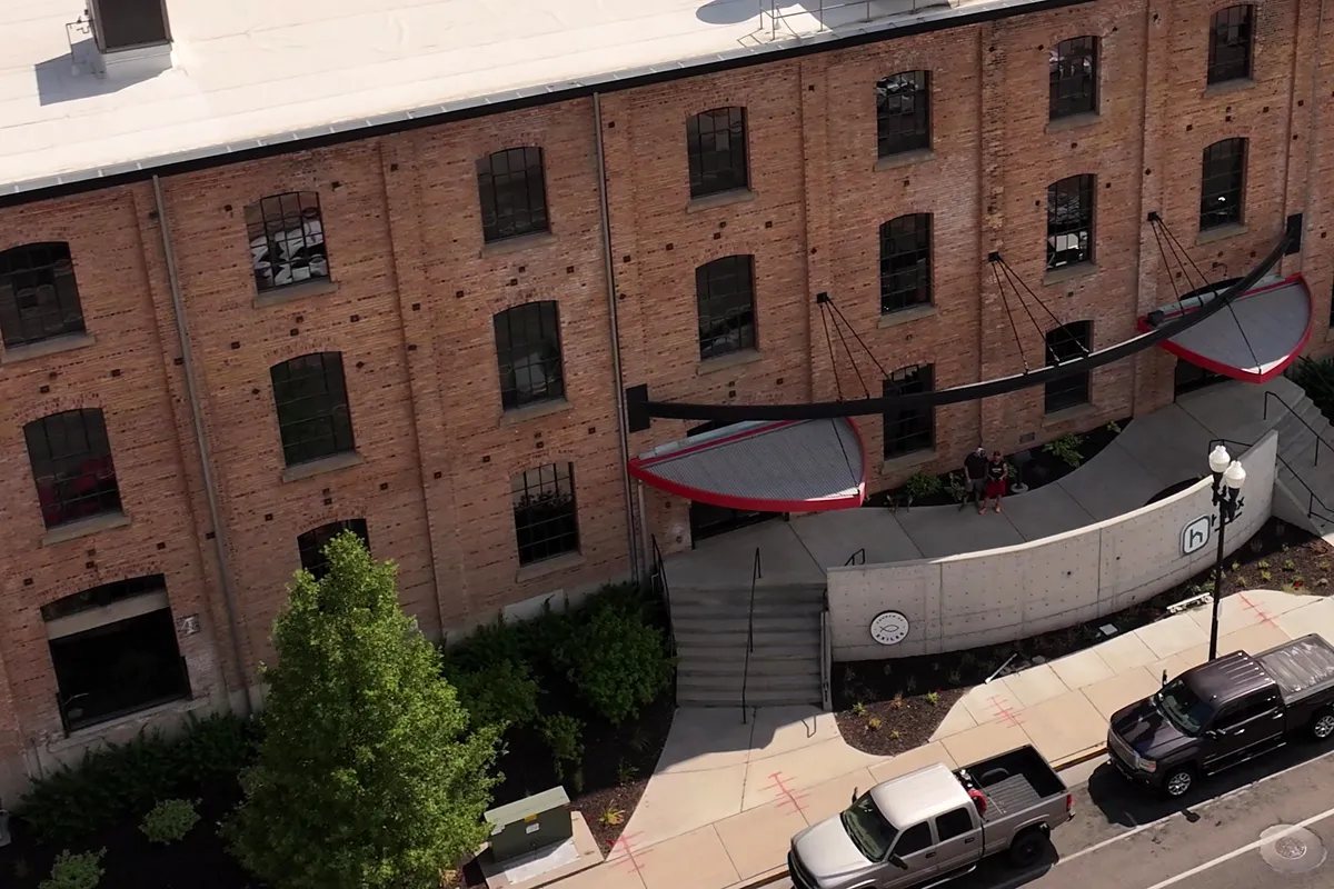 The Church of Exiles brick building on 20th Street, with red entrance awnings, front steps and our round sign